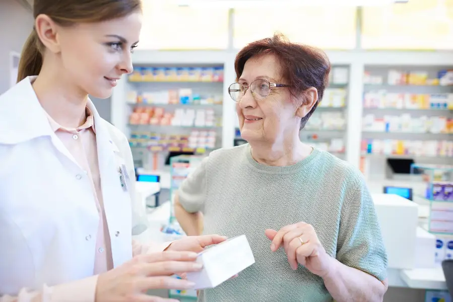 Female pharmacist assisting senior woman